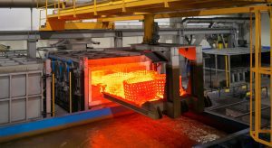 Pictured here is a fresh batch of forgings finishing their heat treatment cycle in our state of the art heat treat machine. This machine automatically loads, unloads, quenches and cools forgings in accordance to ASTM requirements and constantly monitors temperatures throughout the cycle.