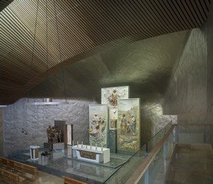 This alter inside a chapel has been lined with wavy panels in a soft grey colour. By using soft titanium, it was possible to make delicate concaveconvex process, creating the desired cave-like feeling in this space.