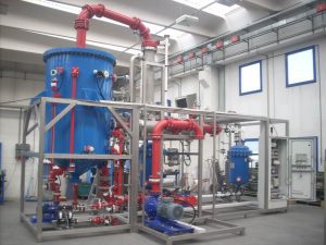 Evaporative units recover free volatile acids such as hydrofluoric and nitric acids by distillation.